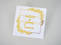 A square sticker with a leaf border around the edges. The names of the happy couple in a lovely handwritten font and the wedding date at the bottom of the names. The design is adorned with a lovely metallic foil for an amazing shine.