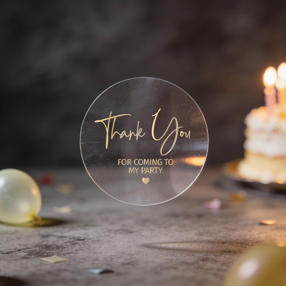 A transparent clear sticker with "Thank You for Coming to My Party" text written in silver foil.