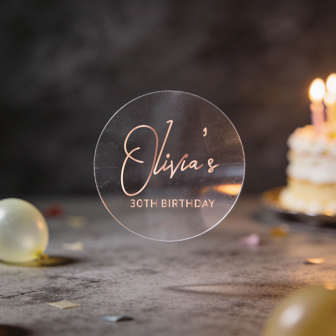 A transparent clear stickers with "Olivia's 30th Birthday" written in gold foil.