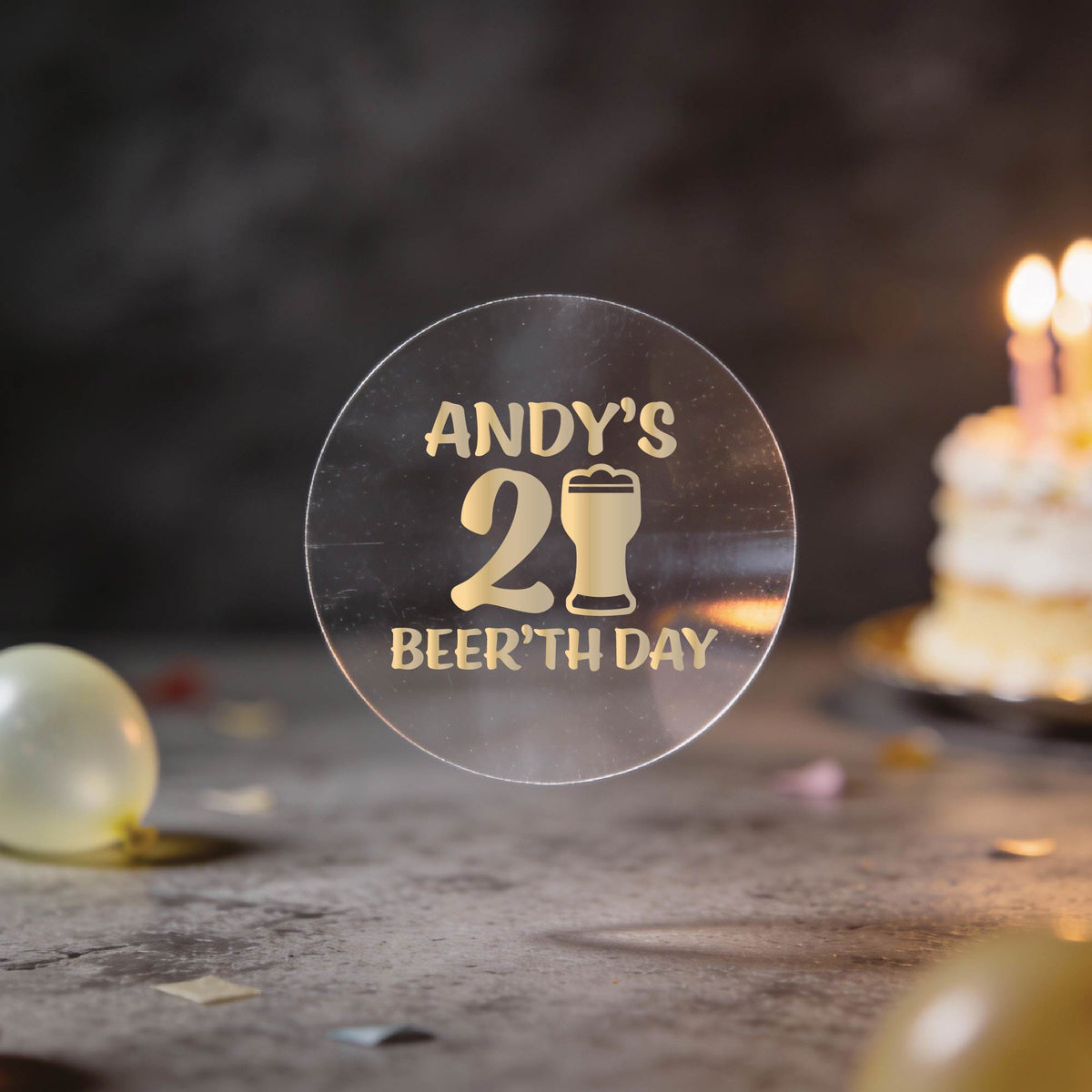A clear round sticker with gold foil text reading 'ANDY'S 21st BEER'TH DAY' and a beer glass icon.