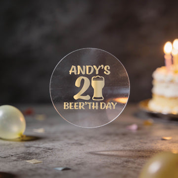 A clear round sticker with gold foil text reading 'ANDY'S 21st BEER'TH DAY' and a beer glass icon.