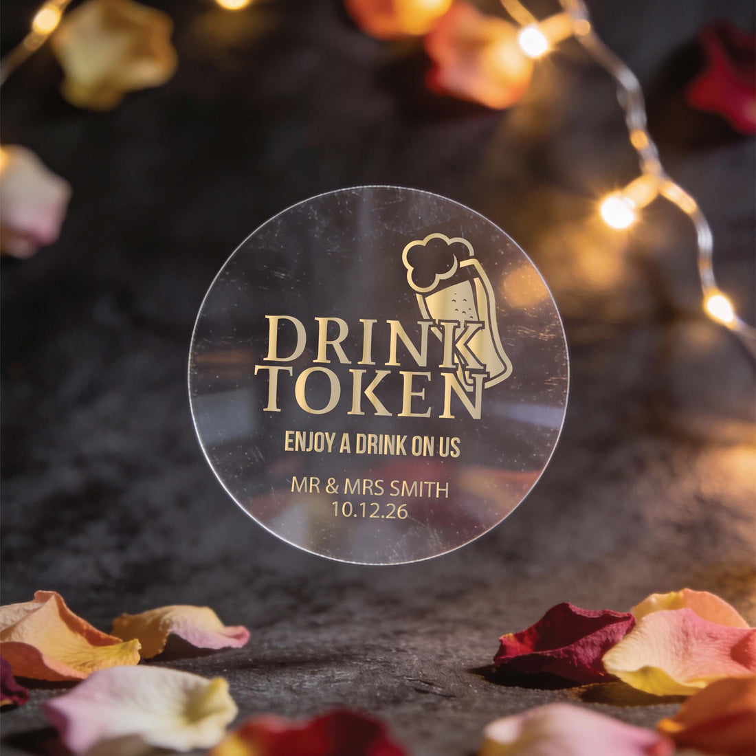 A transparent gold foil round sticker with "drink token: with "Enjoy a drink on us" text and a beer mug icon.