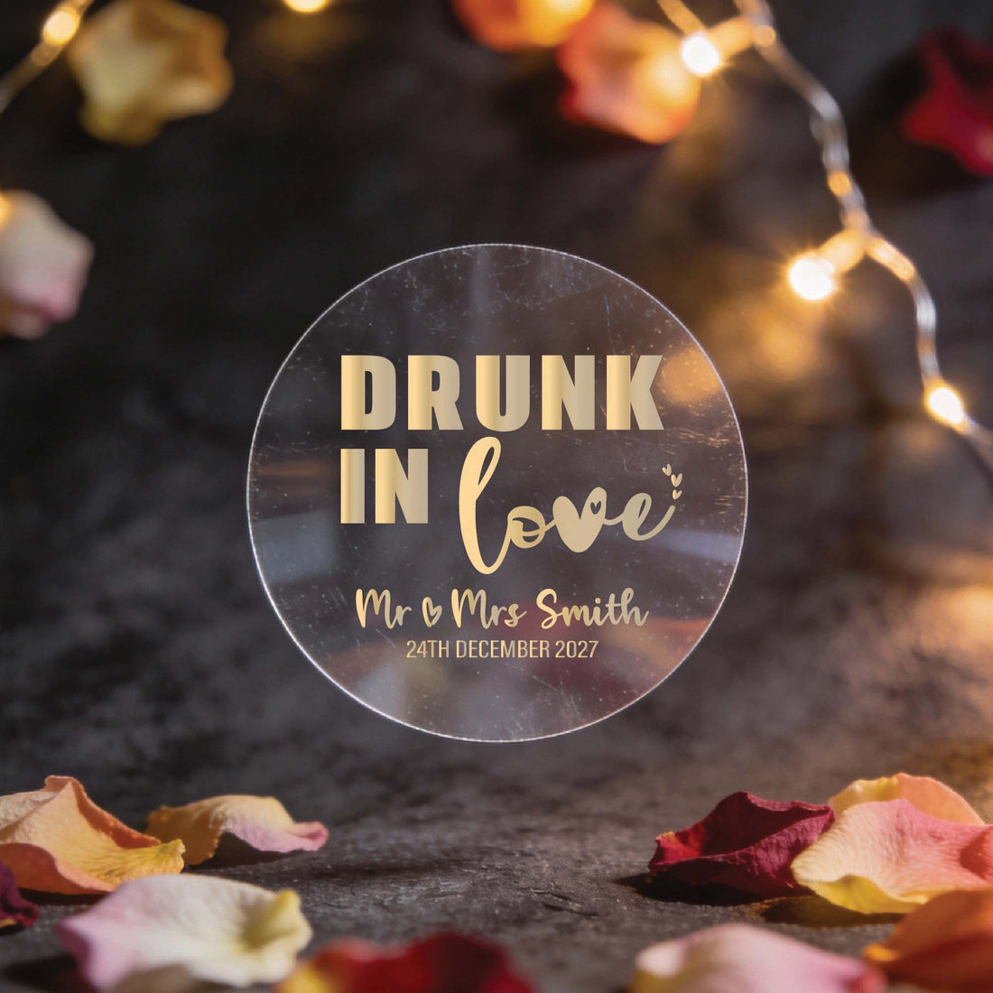 Round clear sticker with gold foil writing saying "Drunk in Love" above "Mr & Mrs Smith, 24th December 2027". Perfect for mini alcohol bottles and shot glasses.