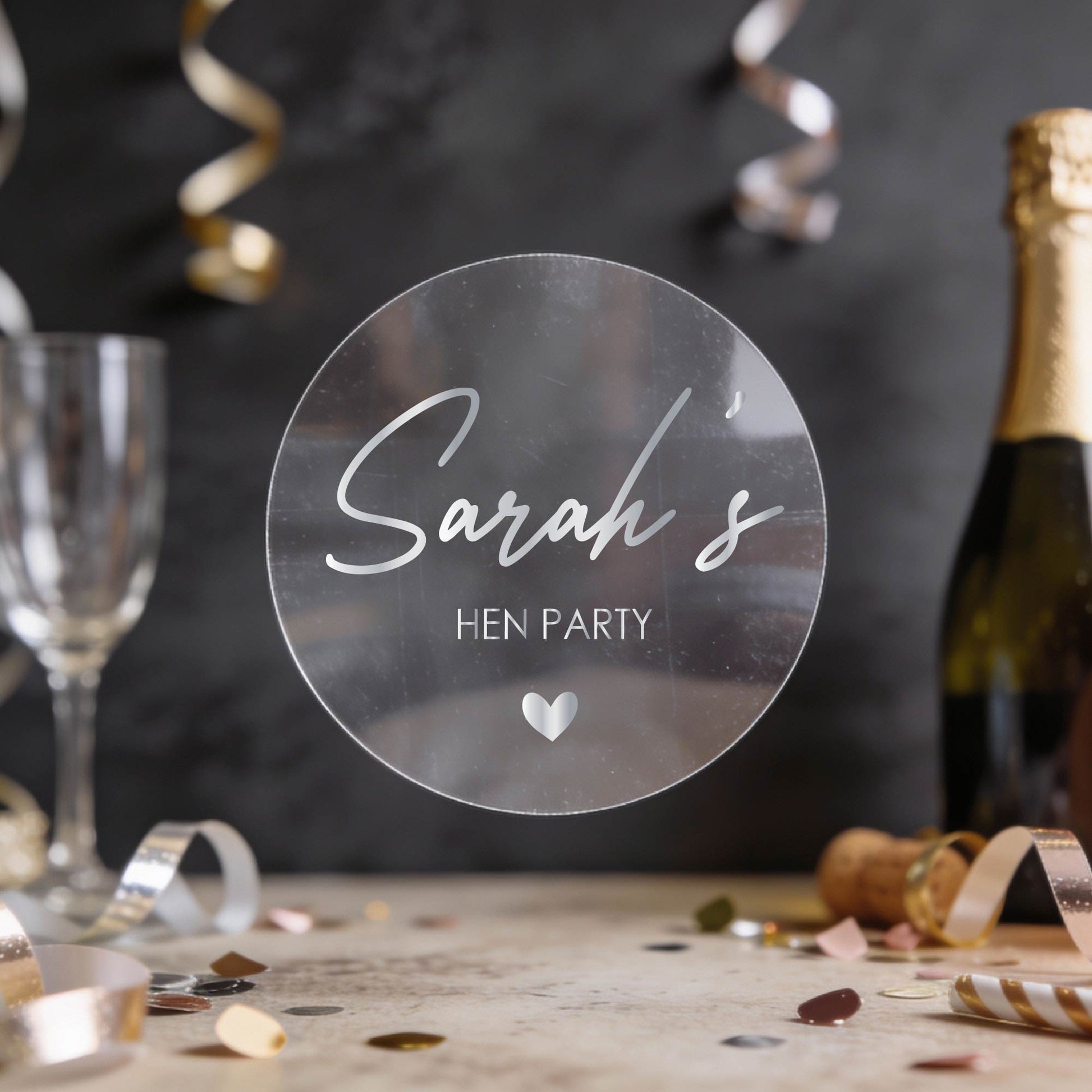 Personalised 'Sarah's Hen Party' round transparent sticker written in silver foil. 