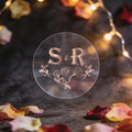 A round, clear sticker with rose gold foil initials 