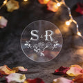 A round, clear sticker with silver foil initials 