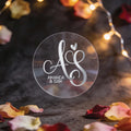 A round, transparent sticker with elegant silver foil initials 
