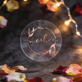 A round, transparent sticker with the initials 