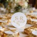 A round, white gloss sticker with gold foil initials 