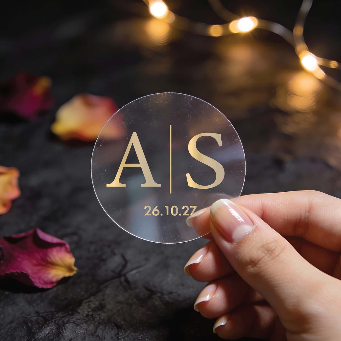 A monogram sticker with initials in the centre separated by a line in the middle and a date at the bottom finished in gold foil.
