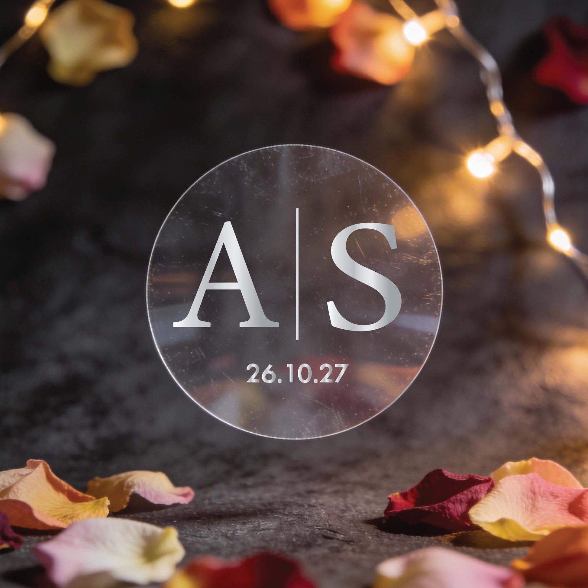 A monogram sticker with initials in the centre separated by a line in the middle and a date at the bottom finished in silver foil.