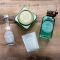 Set of personalized bottles, glass, and container on a wooden surface