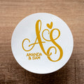 A custom monogram sticker with the letters 'A & S' and the names 'Amanda & Sam' printed in a stylish font, with a gloss white sticker.