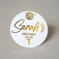 Round white sticker with gold text 'Sarah's Hen Party' and a disco ball design on a grey background