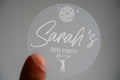 Printed using white ink, the bride-to-be's name is centre in a lovely handwriting font. There is an image of a disco ball and dancing queen at the top and bottom of the sticker to match the party theme of the hen party.