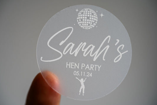 Printed using white ink, the bride-to-be&#39;s name is centre in a lovely handwriting font. There is an image of a disco ball and dancing queen at the top and bottom of the sticker to match the party theme of the hen party.