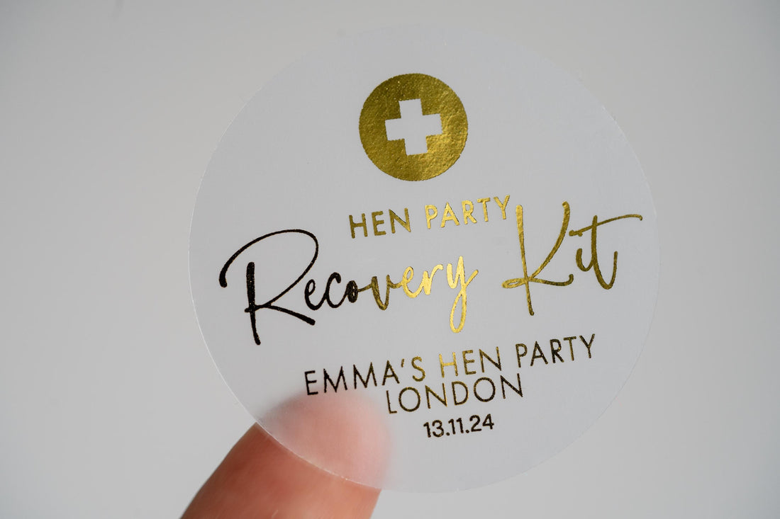 Adorned with a lovely metallic gold foil, "Recovery Kit" written in the centre using a lovely handwriting font. The bride-to-be's name at the bottom with the date of the hen party at the bottom. On the top is the emblem of the red cross in foil.
