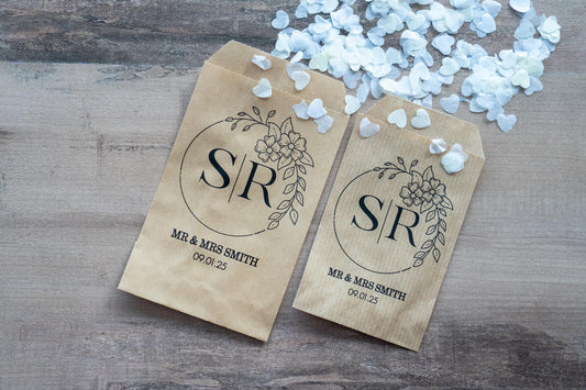 Custom Monogram confetti envelopes with the initials of the bride and groom wrapped around a floral border. The name and date of the happy couple sits at the bottom, you have the option to add a metallic foil for a lovely finish.