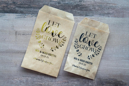 Custom wedding favour for guests to put flower seeds inside. &quot;Let love grow&quot; written on the top with a leaf frame around the words. The name and date of the happy couple sits in the middle and &quot;Plant me & Let Love Grow&quot; written on the bottom.