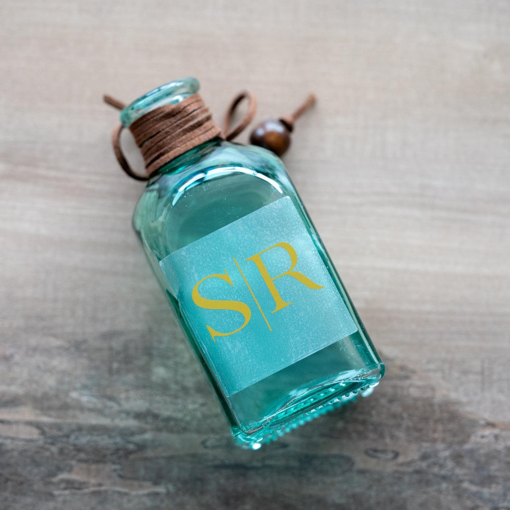 Frosted Clear Sticker with gold foil and initials 'S' and 'R' on a light gray background