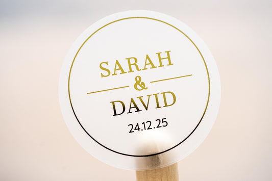 A personalised wedding sticker with a round border. The names of the couple is separated with a line and &quot;&&quot; symbol. The date finishes the sticker, the design is adorned with a lovely metallic gold foil for an amazing shine.