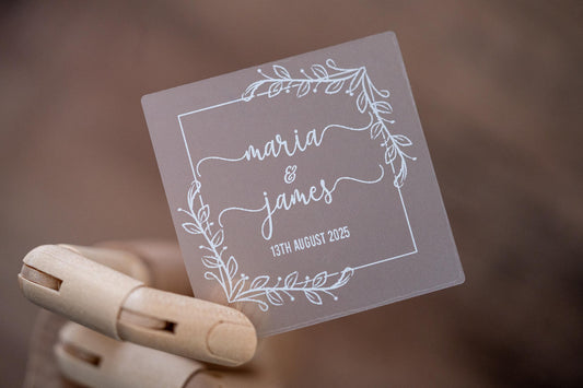 Frosted clear square sticker with a leaf square border. The names of the happy couple sit in the middle of the sticker using a lovely handwritten font. The wedding date finishes the sticker, the sticker is printed using a lovely white ink.
