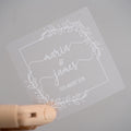 Frosted clear square sticker with a leaf square border. The names of the happy couple sit in the middle of the sticker using a lovely handwritten font. The wedding date finishes the sticker, the sticker is printed using a lovely white ink.