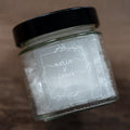 Glass jar with black lid and Frosted clear square sticker with a leaf square border. The names of the happy couple sit in the middle of the sticker using a lovely handwritten font. The wedding date finishes the sticker, the sticker is printed using a lovely white ink.