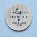 Custom brown kraft stickers in a choice of white and black ink. On the stickers are written Her Favourite and the name of the married couple on the bottom. 