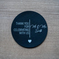 Round black sticker with white text 