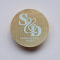 Round kraft sticker with 'S & D' initials and 'Sarah & David 10.10.24' text printed using white ink