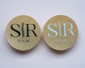 Two kraft stickers with monogram initials and date on a pink background