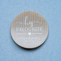Custom brown kraft stickers in a choice of white and black ink. On the stickers are written His Favourite and the name of the married couple on the bottom. 