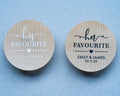 Custom brown kraft stickers in a choice of white and black ink. On the stickers are written His or Her Favourite and the name of the married couple on the bottom. 