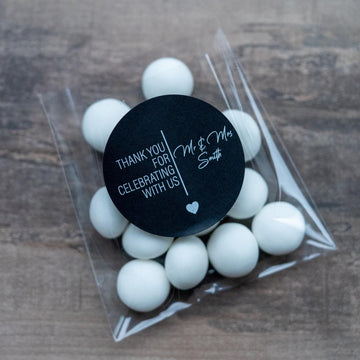 A clear plastic packaging containing white mints with a black personalised sticker on top displaying a thank you message.