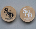 Round kraft stickers with 'S & D' monogram design printed with black and white ink.