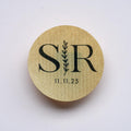 Round kraft paper sticker with 'SR' initials and date on a pink background
