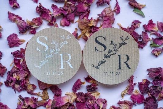 A brown kraft sticker with monogram letters in the middle, separated by a leaf line. The date finishes the sticker at the bottom. The print come in two colours: black and white.
