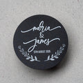 Round black sticker with 'Maria & James' and date printed using white ink