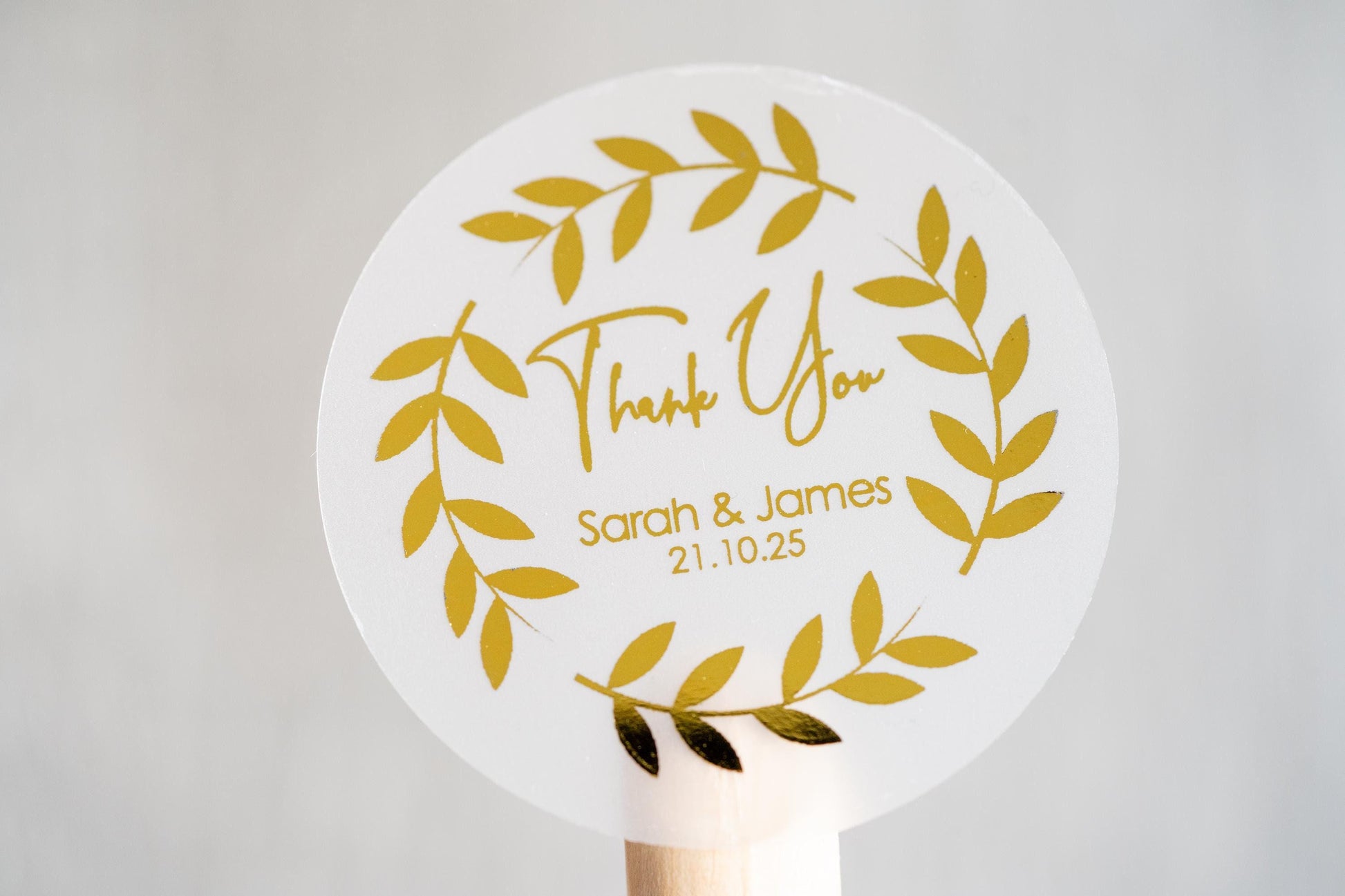 Thank you sticker with a round leaf border. The name of the couple sits underneath &quot;thank you&quot; written in a handwritten font. The design is finished with metallic foil for a lovely shine.