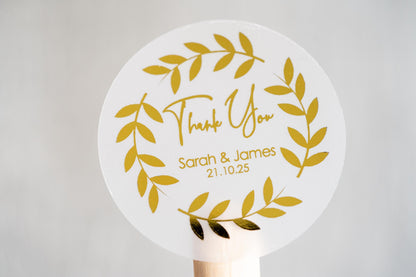 Thank you sticker with a round leaf border. The name of the couple sits underneath &quot;thank you&quot; written in a handwritten font. The design is finished with metallic foil for a lovely shine.