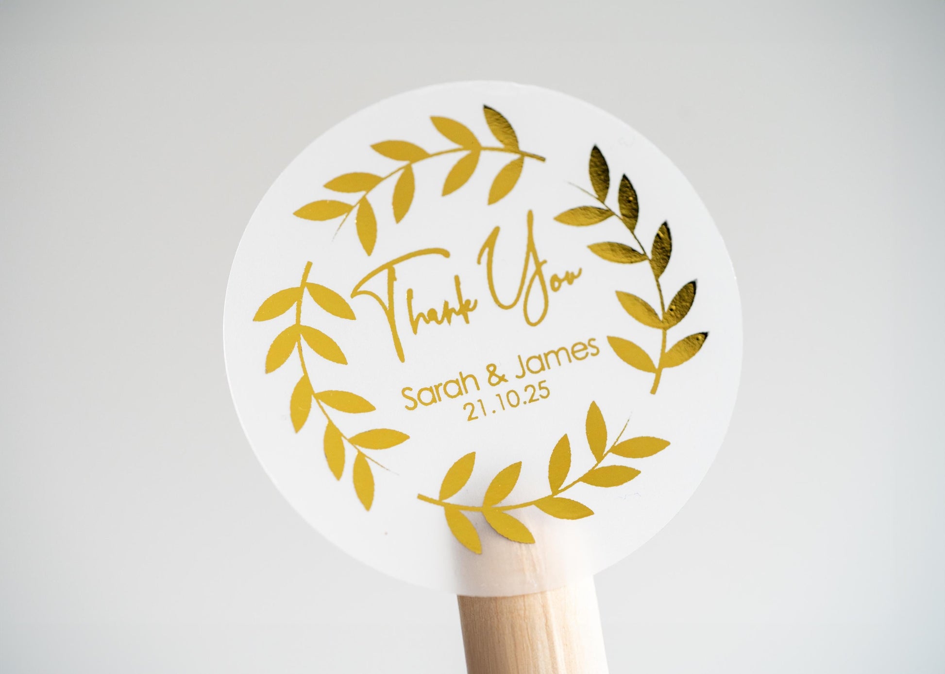 Thank you sticker with a round leaf border. The name of the couple sits underneath &quot;thank you&quot; written in a handwritten font. The design is finished with metallic foil for a lovely shine.