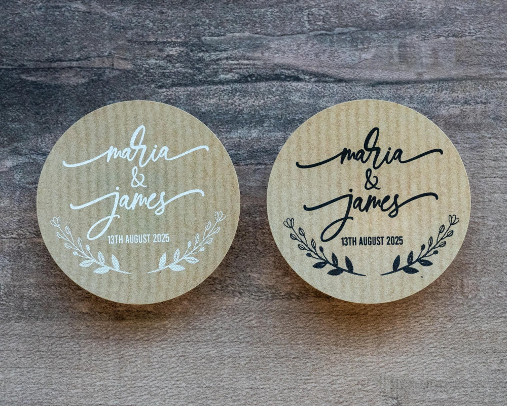 A custom kraft sticker with the names of the happy couple in a lovely handwritten font. The names sit in the middle of the sticker with a wreath frame at the bottom. The stickers come in black or white print.