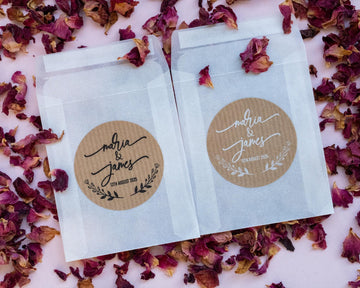 A custom kraft sticker with the names of the happy couple in a lovely handwritten font. The names sit in the middle of the sticker with a wreath frame at the bottom. The stickers come in black or white print.